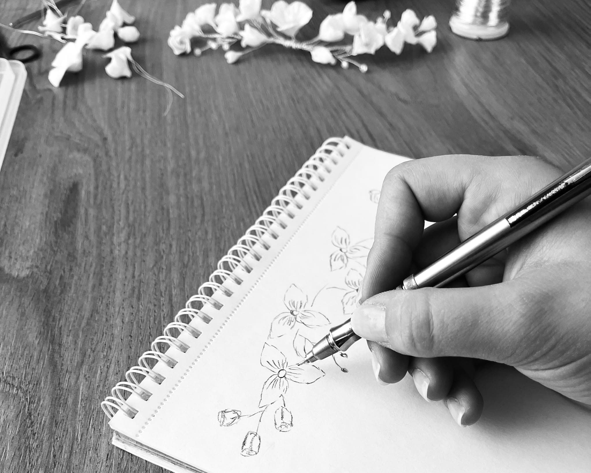 Çiçek motiflerinin defter üzerine çizildiği tasarım eskizi